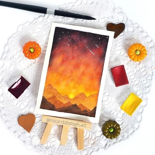 Miranda Balogh watercolour galaxy mountains. This is an example of flat lay for artists. Learn how to take flat lay pictures of your artwork so that you can post them on Instagram and other social media accounts.