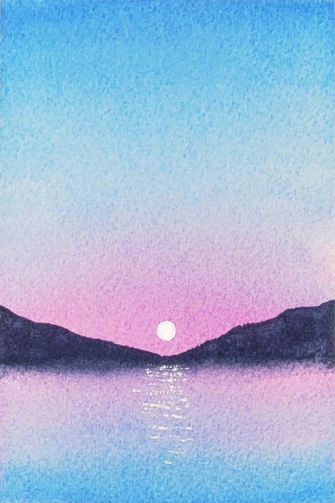 To create this easy watercolour lake with a moon, the fourth and final step is to load up your brush with white gouache again to add more moon reflections on the water. Use the dry brush technique to build up the light values.