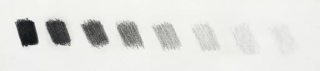 There is an image of a graphite value scale. There are 8 values in total. On the right are the light values, in the middle are the midtones, and on the left are the dark values.